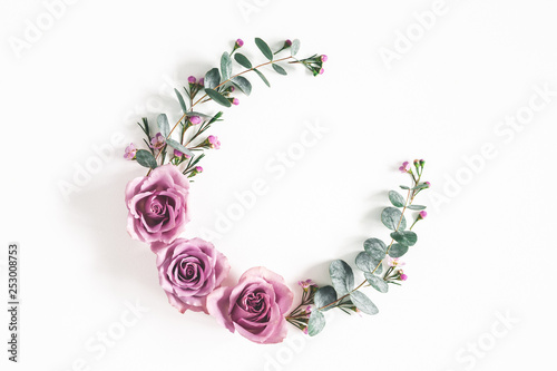 Flowers composition. Wreath made of eucalyptus branches and rose flowers on white background. Flat lay, top view, copy space