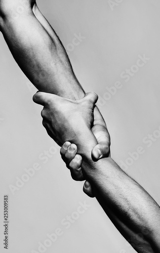 Rescue, helping gesture or hands. Strong hold. Two hands, helping hand of a friend. Handshake, arms, friendship. Friendly handshake, friends greeting, teamwork, friendship. Close-up. Black and white photo