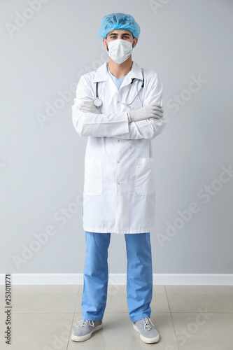 Male doctor near light wall