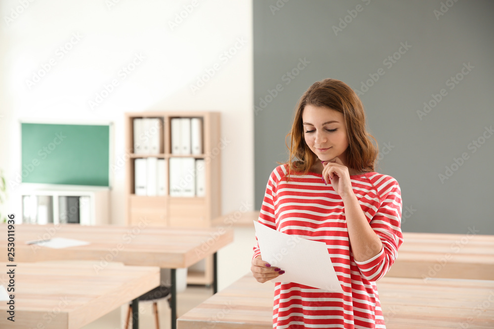 Girl with results of school test in classroom Girl with results of school test in classroom