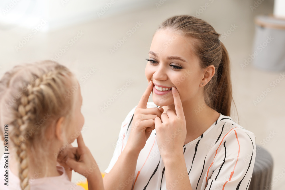 Speech therapist working with little girl in office