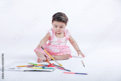 Cute little Indian/Asian Girl enjoying Painting  with paper, colour pencle and art brush photo