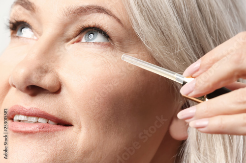 Mature woman applying face ...