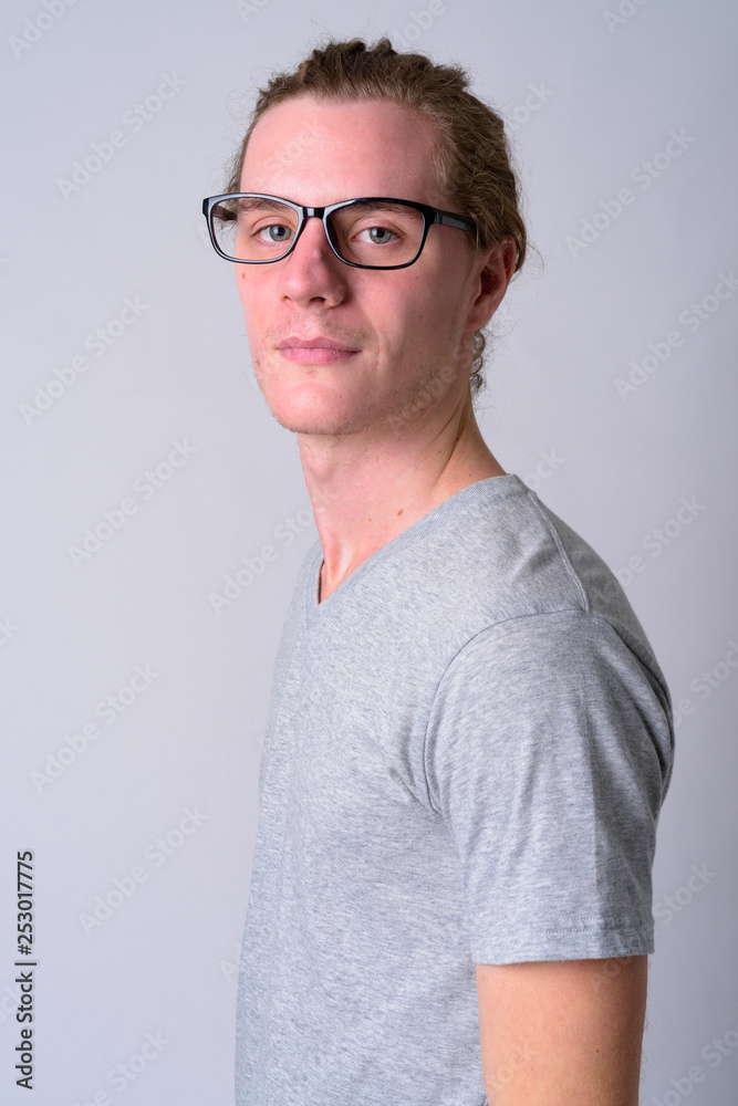Profile view of young handsome man with eyeglasses looking at camera Profile view of young handsome man with eyeglasses looking at camera
