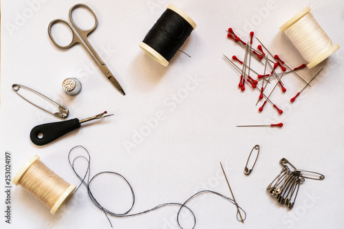 Quick fix sewing kit accessories and tailor equipment for sewing and repairing. Accessories and tools for needlework: scissors, thread spools, needles, pins and safety pins, thimble, flat lay.