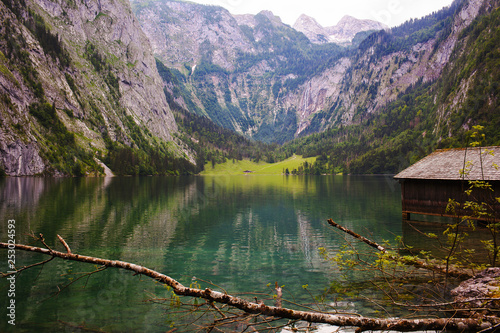 House on the shore of a large Obersee lake in the Alps with logs and stones photo