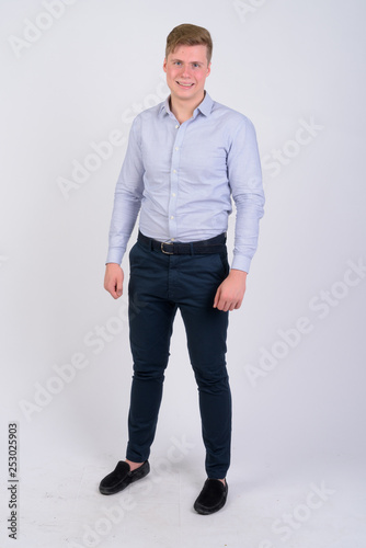 Full body shot of young happy blonde businessman smiling