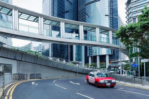 Street scene of the downtown at day in China. Hong Kong city Central street at Western District. Blurred taxi car move on road. City structure.