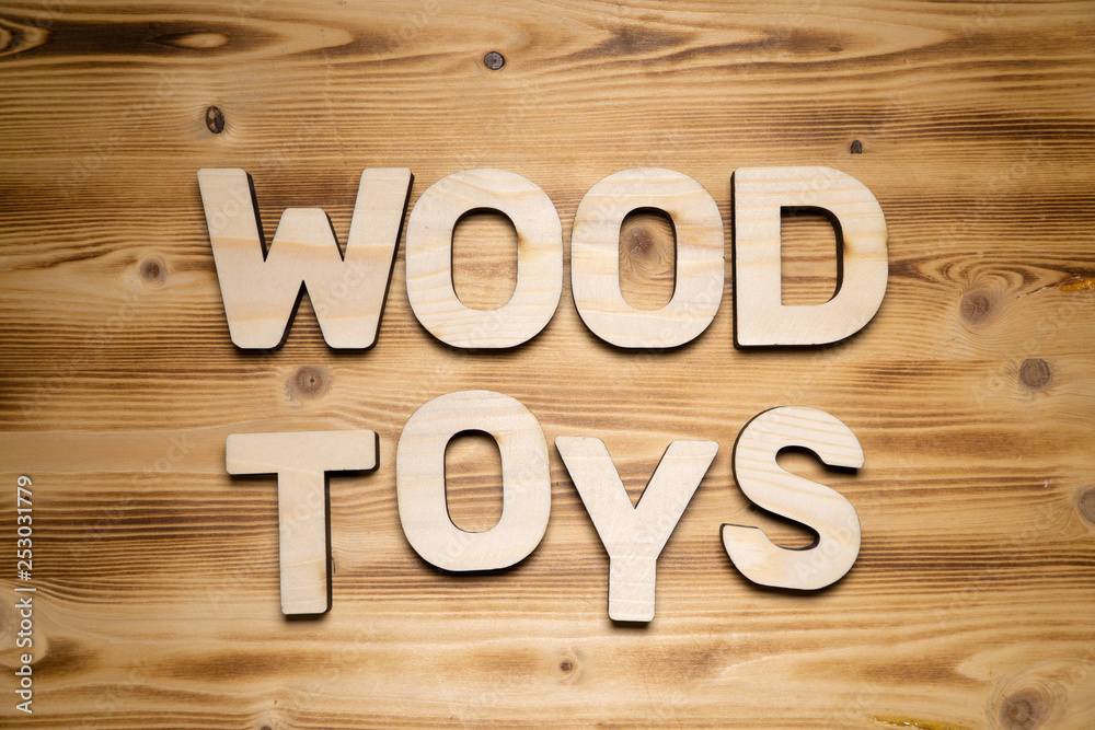 WOOD TOYS words made of wooden block letters on wooden board, top view. WOOD TOYS words made of wooden block letters on wooden board, top view.
