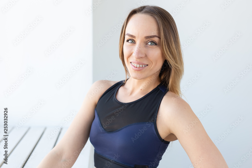 people, sport and fitness concept - portrait of young brunette fitness woman on white background
