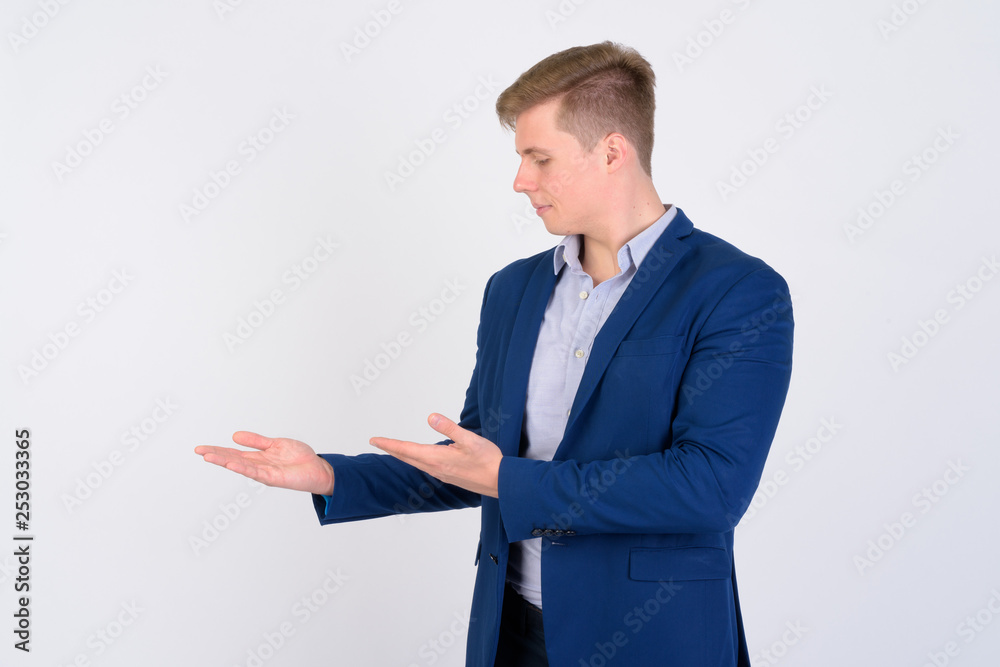 Portrait of young handsome blonde businessman showing something