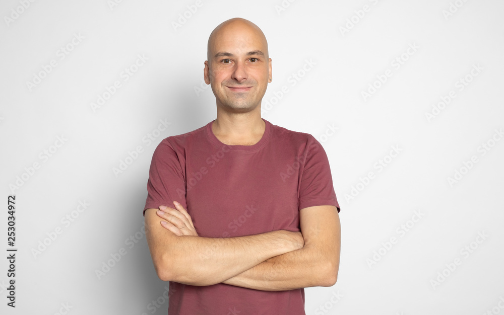 Confident casual bald man smiling with arms crossed Confident casual bald man smiling with arms crossed