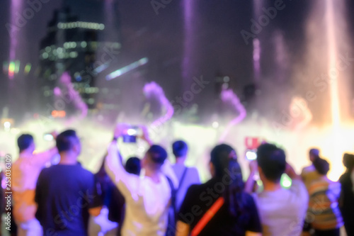 Blurred scene people seeing show of laser light with fountain event