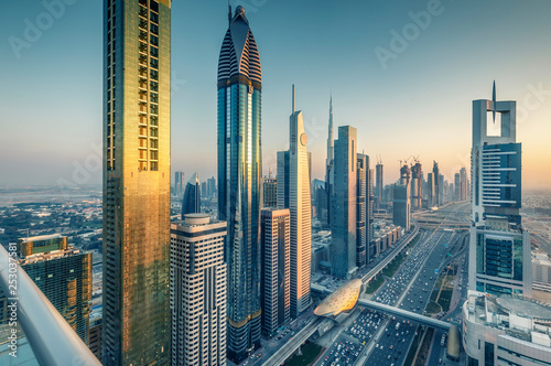 Skyscrapers and highways of a big modern city at sunset. Aerial view on downtown Dubai, United Arab Emirates.