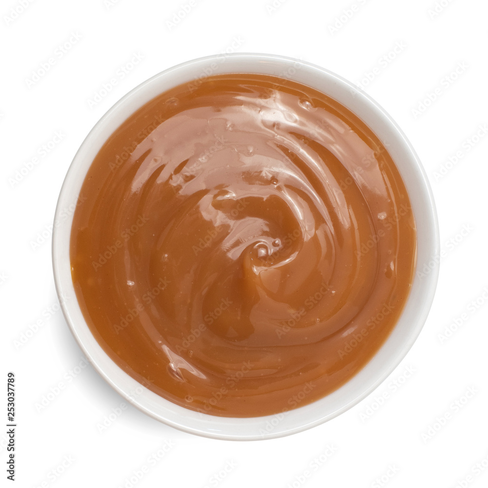 Sweet caramel sauce in bowl isolated on white background. Top view Sweet caramel sauce in bowl isolated on white background. Top view