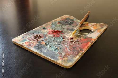 Tavolozza in legno per dipingere e pennello, colori ad olio, oggetti artistici photo
