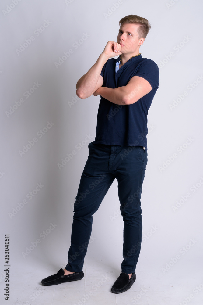 Full body shot of young blonde handsome man thinking Full body shot of young blonde handsome man thinking