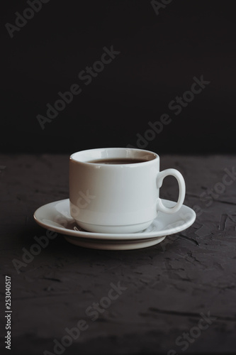 White cup of coffee on a dark background