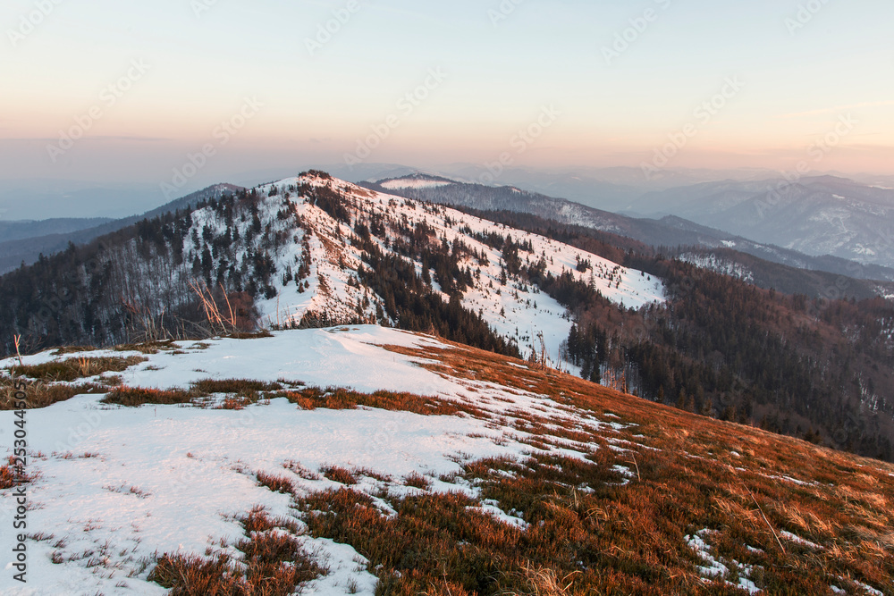 The wonderful landscape of the Carpathians in the early spring, the Beskydy region. beautiful view of the Carpathian mountains (Beskydy region) at sunset is partly covered with snow.