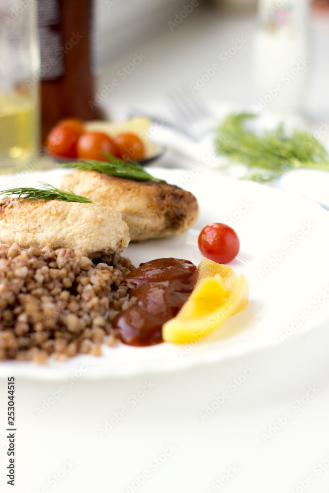 Chicken cutlets with buckwheat, herbs, ketchup and tomatoes