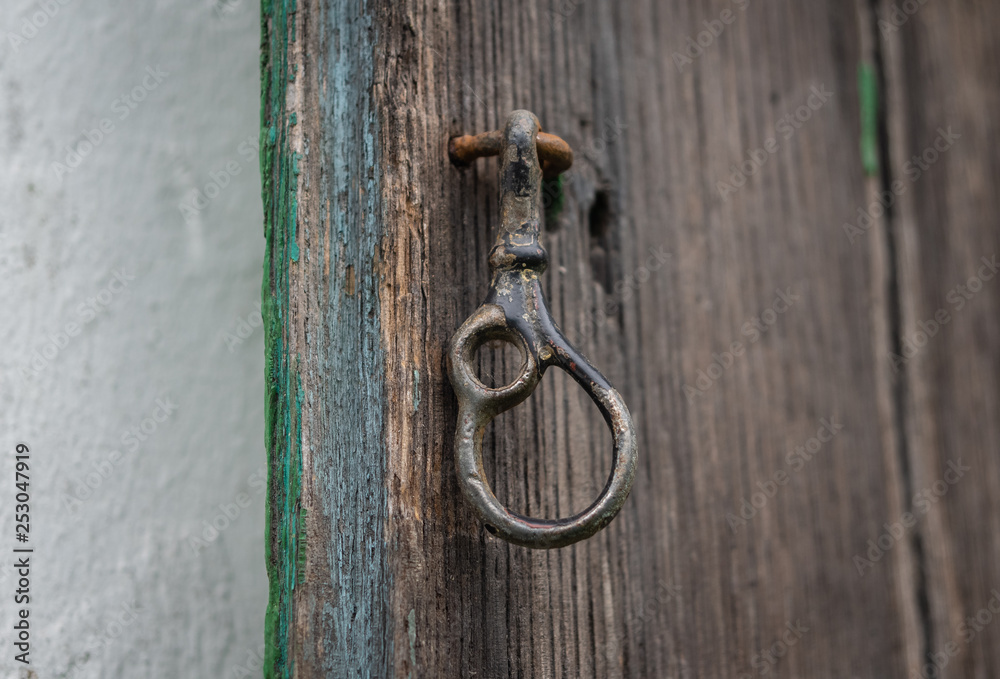 The iron latch on a wooden door
