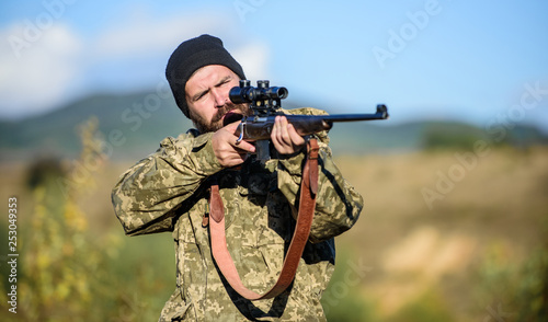 Man brutal gamekeeper nature background. Bearded hunter spend leisure hunting. Hunter hold rifle. Focus and concentration of experienced hunter. Hunting and trapping seasons. Hunting permit