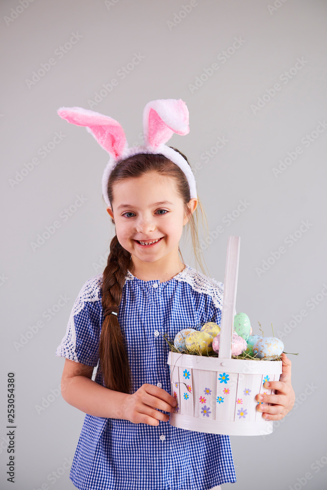 Smiling girl holding a basket of easter eggs Smiling girl holding a basket of easter eggs