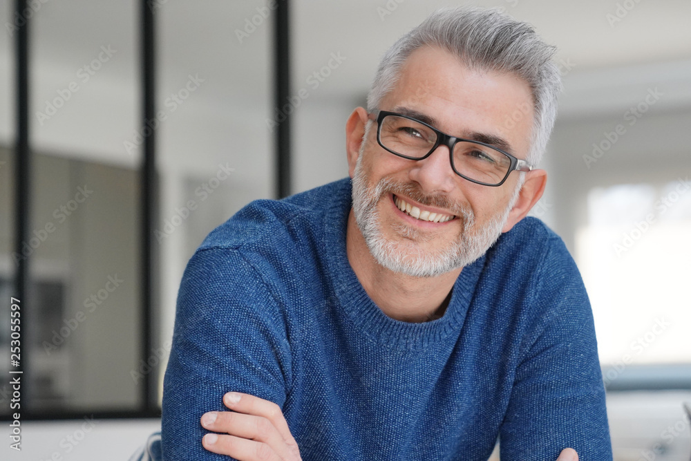 Portrait of smiling man with grey hair and glasses - obrazy, fototapety, plakaty 