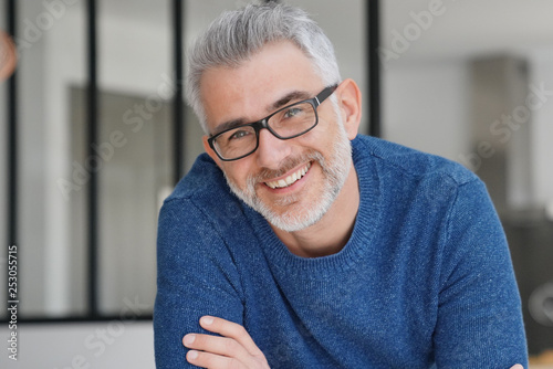 Portrait of smiling man with grey hair and glasses