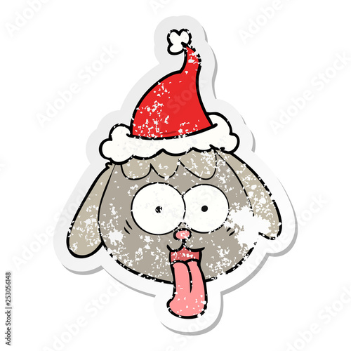 distressed sticker cartoon of a dog face panting wearing santa hat