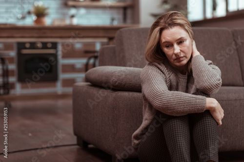 Woman wearing brown squared trousers feeling depressed photo