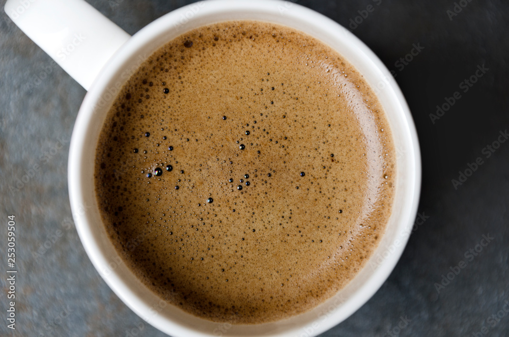 Closeup of coffee foam.Coffee in white cup,top view Closeup of coffee foam.Coffee in white cup,top view