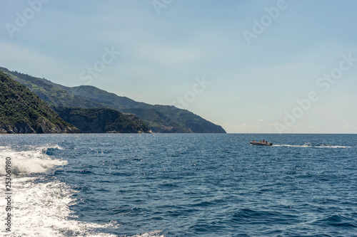 Italy, Cinque Terre, Monterosso, a body of water with a mountain in the background © SkandaRamana