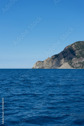Italy, Cinque Terre, Monterosso, a large body of water with a mountain in the ocean © SkandaRamana