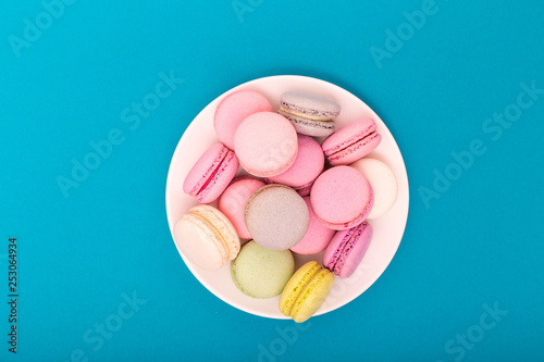 Blue macaroons on a turquoise background, almond cookies in pastel tones close-up, copy space