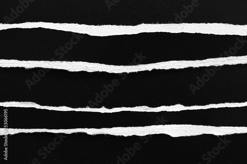 Piece of torn paper on black. Copy space