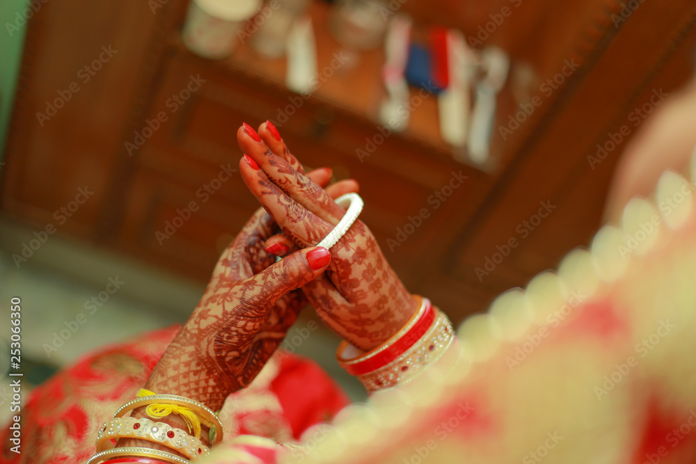 Obraz premium Indian bride wearing wedding traditional red bangles (choora) and getting ready for her wedding ceremony in Delhi, India