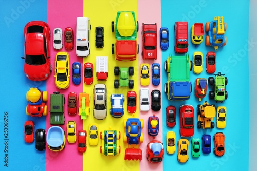 Many colored toy cars on multicolored background