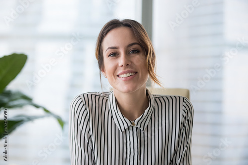 Smiling businesswoman looking at camera webcam make conference business call photo