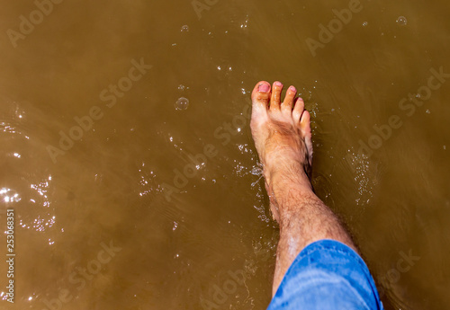 Feet of a man by the sea