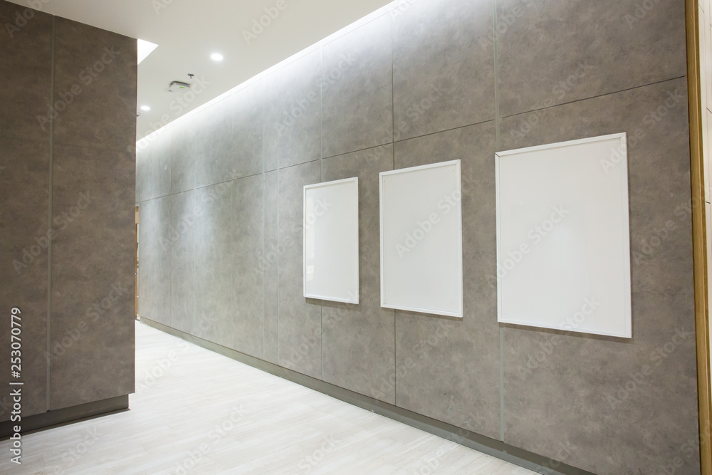 Blank square posters on concrete wall in empty hall Blank square posters on concrete wall in empty hall