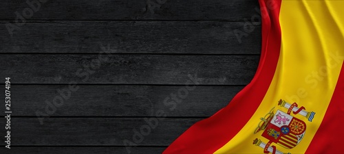 Flag of Spain, fabric on dark wood.