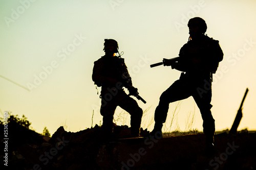 Black silhouettes of pair of soldiers