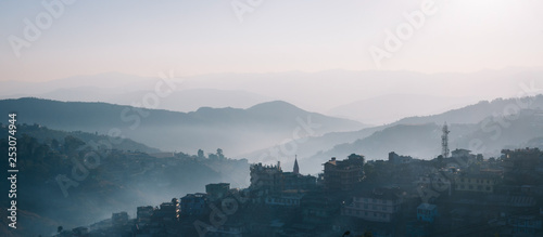 Sunrise over the hillside town of Kohima in Nagaland in India. Moody shot with early morning fog or mist photo