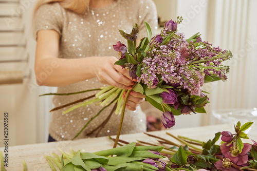 florist making bouquet of tulips, peonies and lilac at workspace © LIGHTFIELD STUDIOS