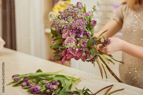 cropped view of florist making bouquet of tulips, peonies and lilac at workspace © LIGHTFIELD STUDIOS