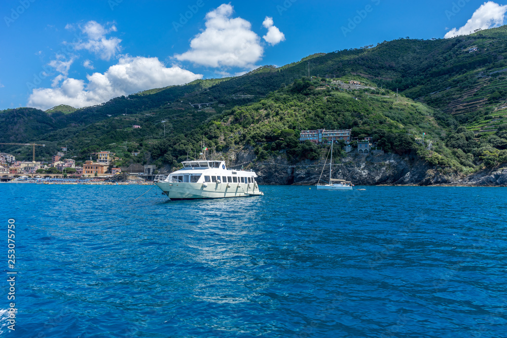 Italy, Cinque Terre, Monterosso, a large body of water with a mountain in the background Italy, Cinque Terre, Monterosso, a large body of water with a mountain in the background