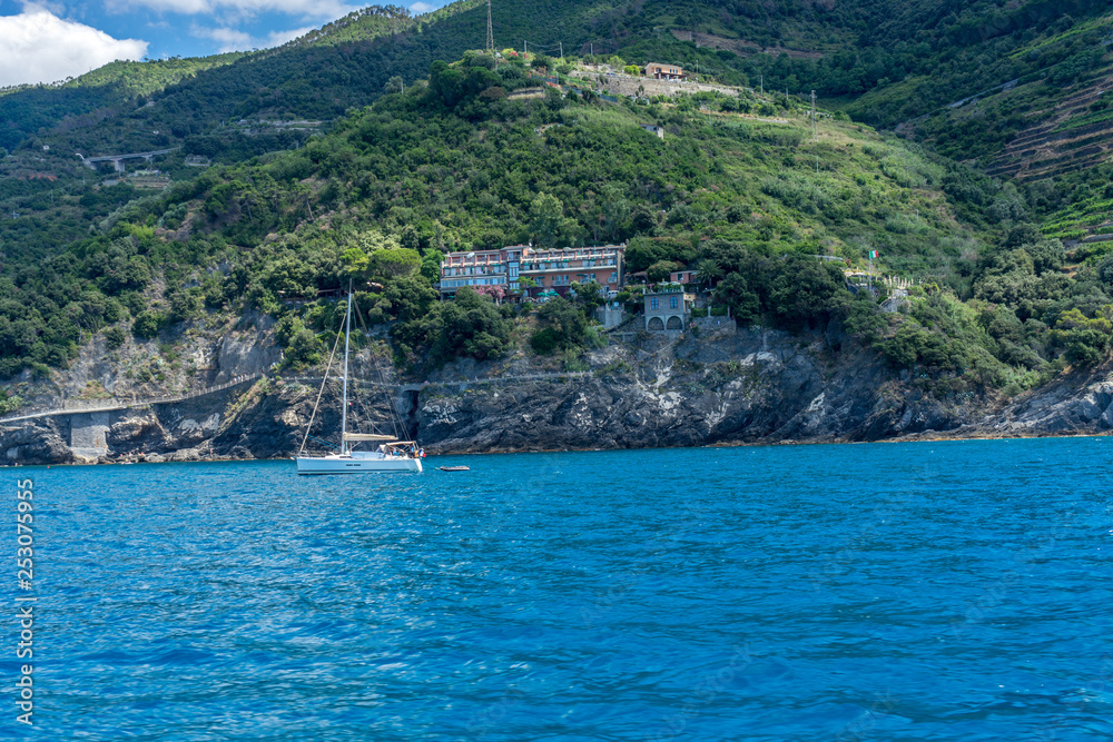 Italy, Cinque Terre, Monterosso, a large body of water with a mountain in the background Italy, Cinque Terre, Monterosso, a large body of water with a mountain in the background