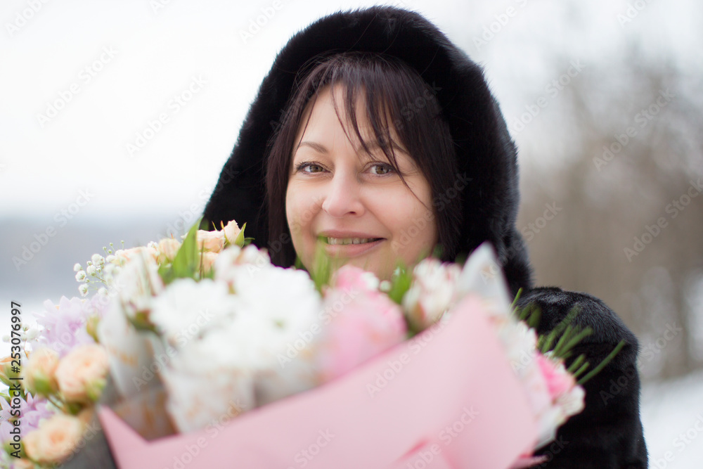 Middle-aged woman with a bouquet of flowers in winter Middle-aged woman with a bouquet of flowers in winter
