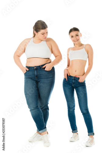 sad overweight woman jealously looking at smiling slim beautiful woman isolated on white